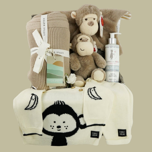 baby hamper with organi clothing set in cream with a black monkey face, soft organic blanket in beige, soft eco friendly monkey plush and matching monkey comforter, soft baby lotion organic 