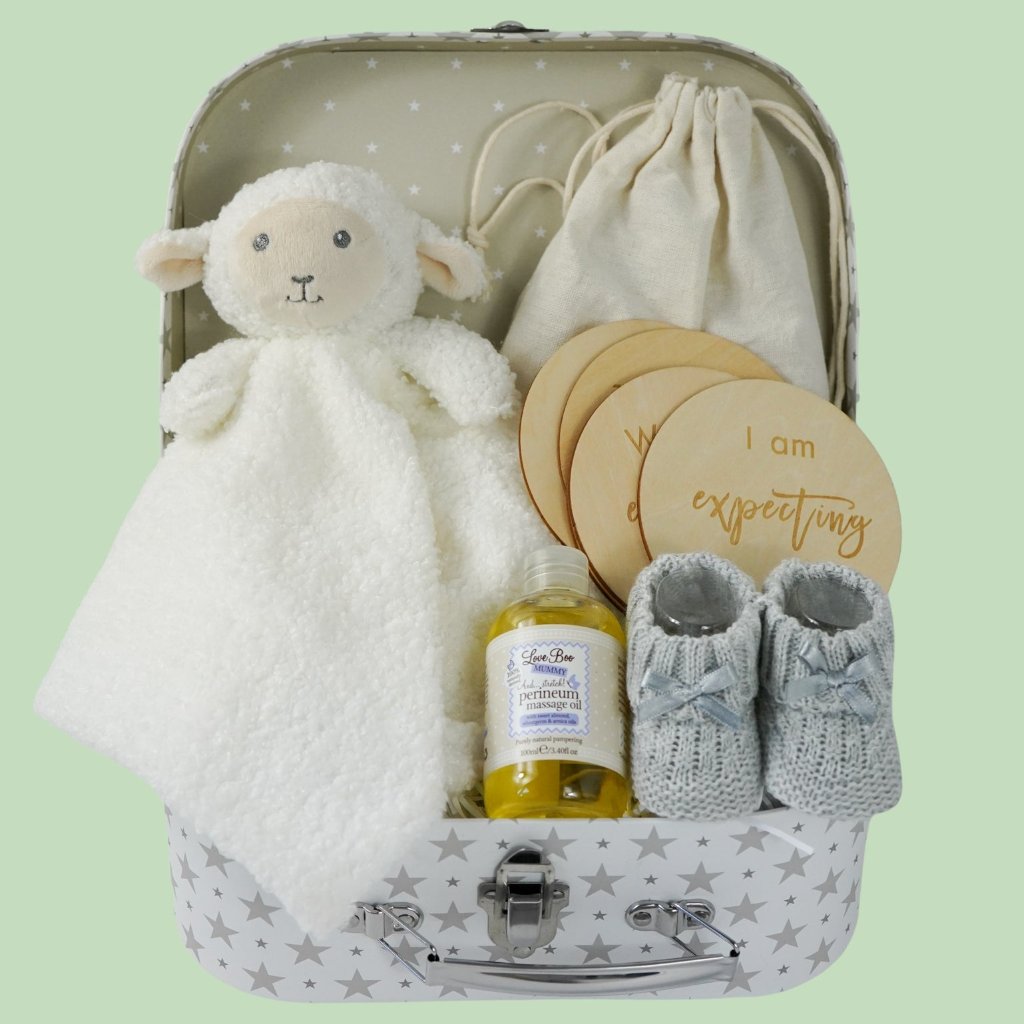 pregnancy hamper in a grey with white star case lamb comforter, grey booties, perineum oil, pregnancy milestone discs