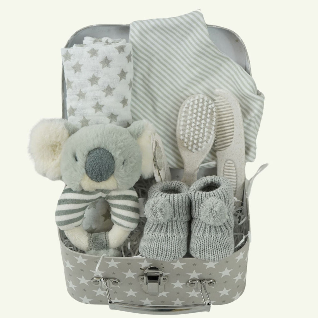 grey storage case hamper with cute grey and white koala ring rattle, baby muslin in grey and white , baby striped grey and white bib, grey booties and beige com and brush set 