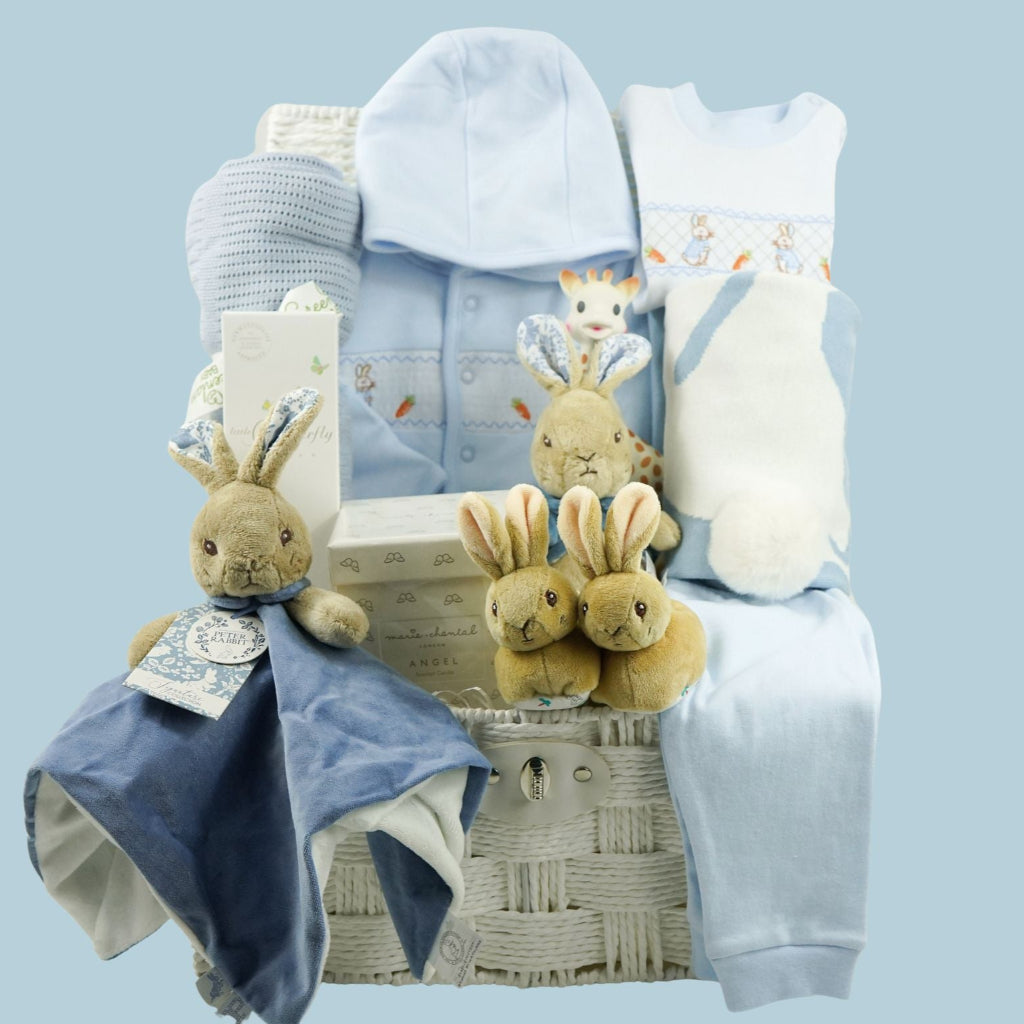 luxury baby boy gift hamper Peter rabbit themed baby clothing set includes a pale blue jacket with peter rabbit embroidered, peter rabbit comforter and soft toy, peter rabbit slippers, luxury candle, baby toiletries, cellular blanket, peter rabbit blue and white blankets with fluffy tail, Sophie La Girafee