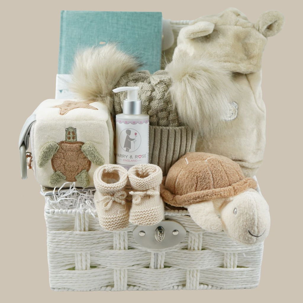 neutral baby hamper with baby dressing own, booties , baby journal, fluffy double pom pom hat, activity cube in neutral green, brown and cream with turtle, star fish and seahorse , soft turtle rattle toy 