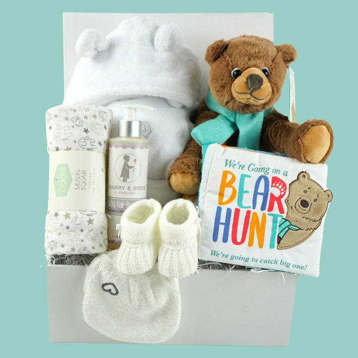 baby hamper basket 'We're going on a Bear hunt book and soft toy, white dressing gown, grey and white muslin, organic baby wash, wash mitt , knit booties 