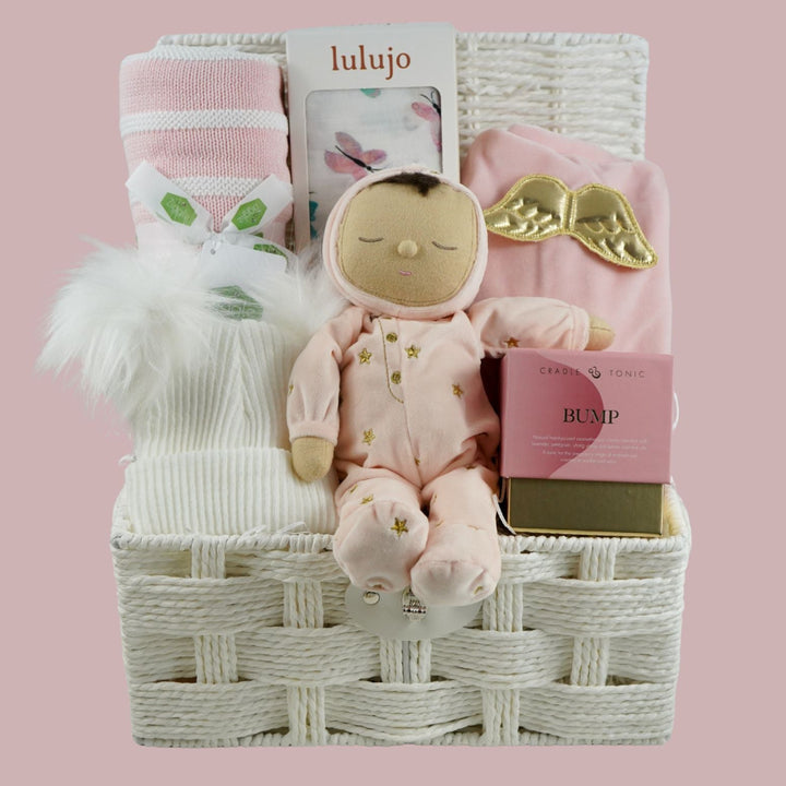 baby girl gift hamper with pink dozy dinkum soft musical doll. baby blanket , white fluffy hat, pink luxury candle, soft luxury baby outfit and swaddle in white with pink butteflies 