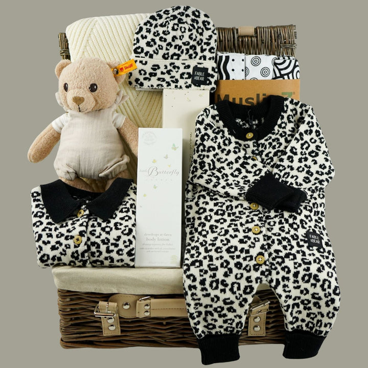 organic baby hamper with cream and black leopard prink knitted romper and  cardigan and matching hat in organic cotton, organic cotton cream blanket, organic steiff teddy, organic toiletries , organic black and white muslins and wooden sutainable hairbrush