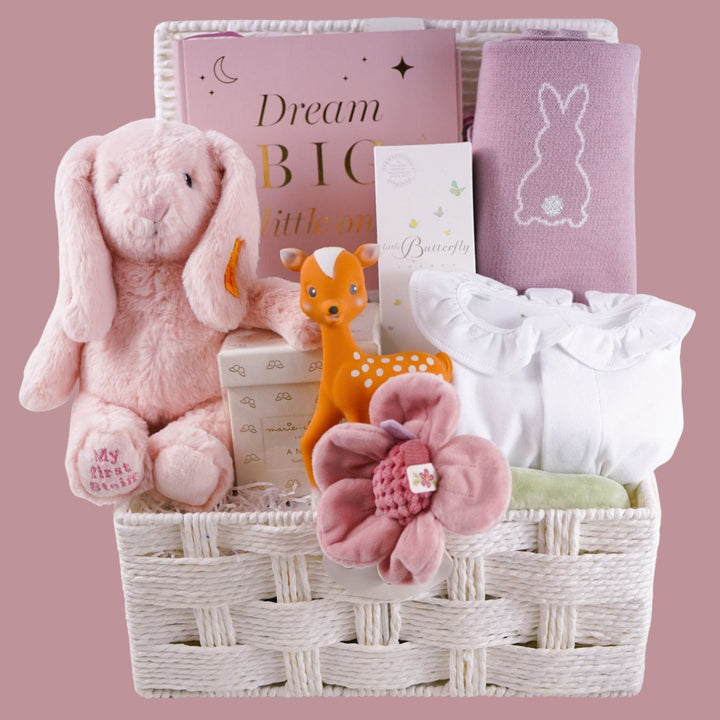 Baby gift basket with Steiff first bunny soft toy in pink, pink photo album,  pink baby blanket with bunny, baby sleepsuit with ruffle, baby organic bubble bath