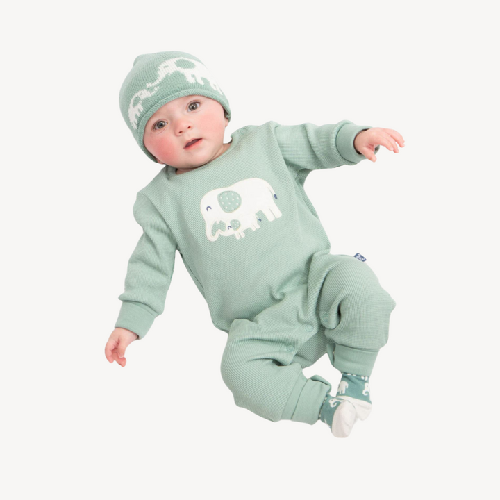 green waffle effect baby romper with cream elephant design, green baby socks with elephants, knit beanie hat in green with elephants