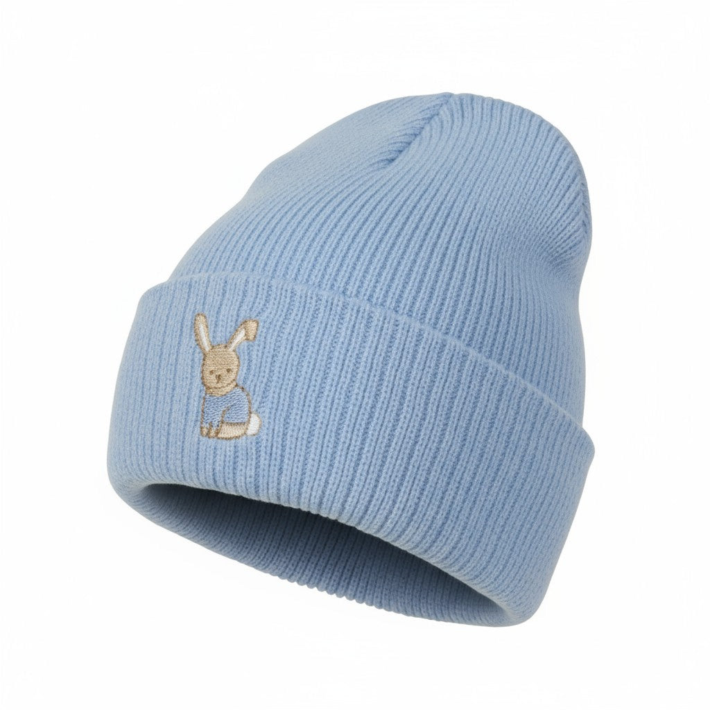 Light blue knit beanie with embroidered character on a white background