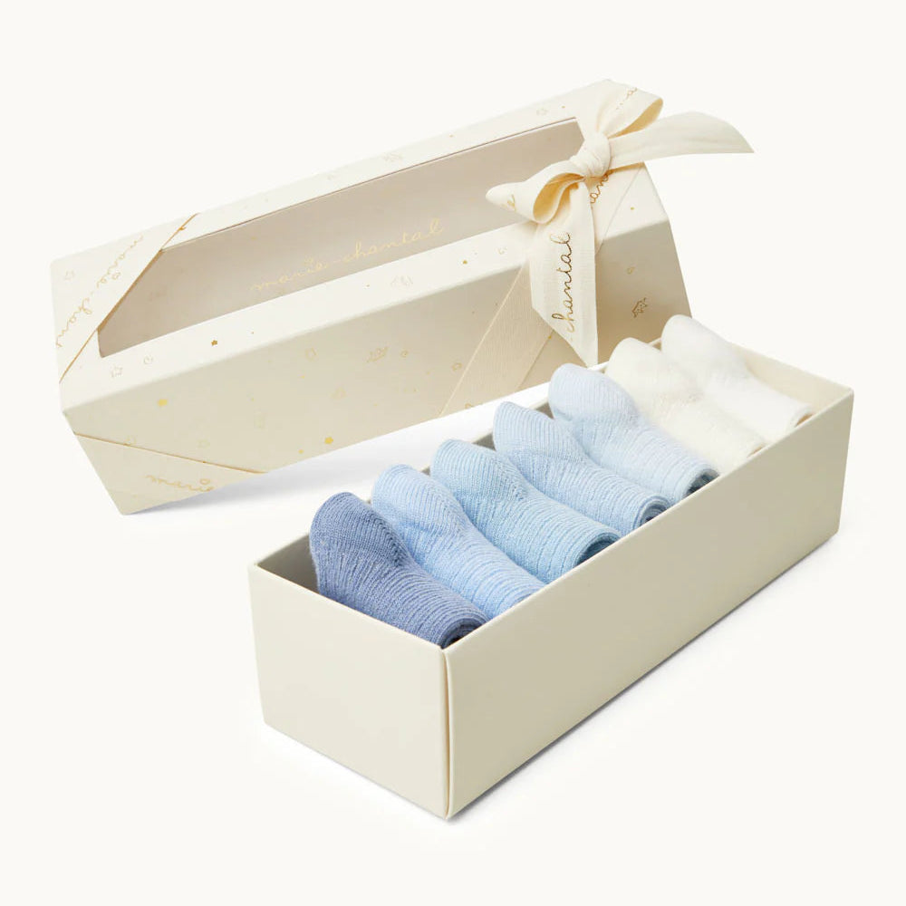 Set of blue baby socks in a gift box with a ribbon on a white background