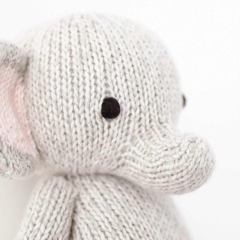 Close-up of a knitted elephant toy on a white background