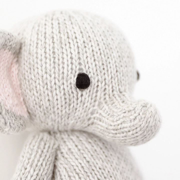 Close-up of a knitted elephant toy on a white background