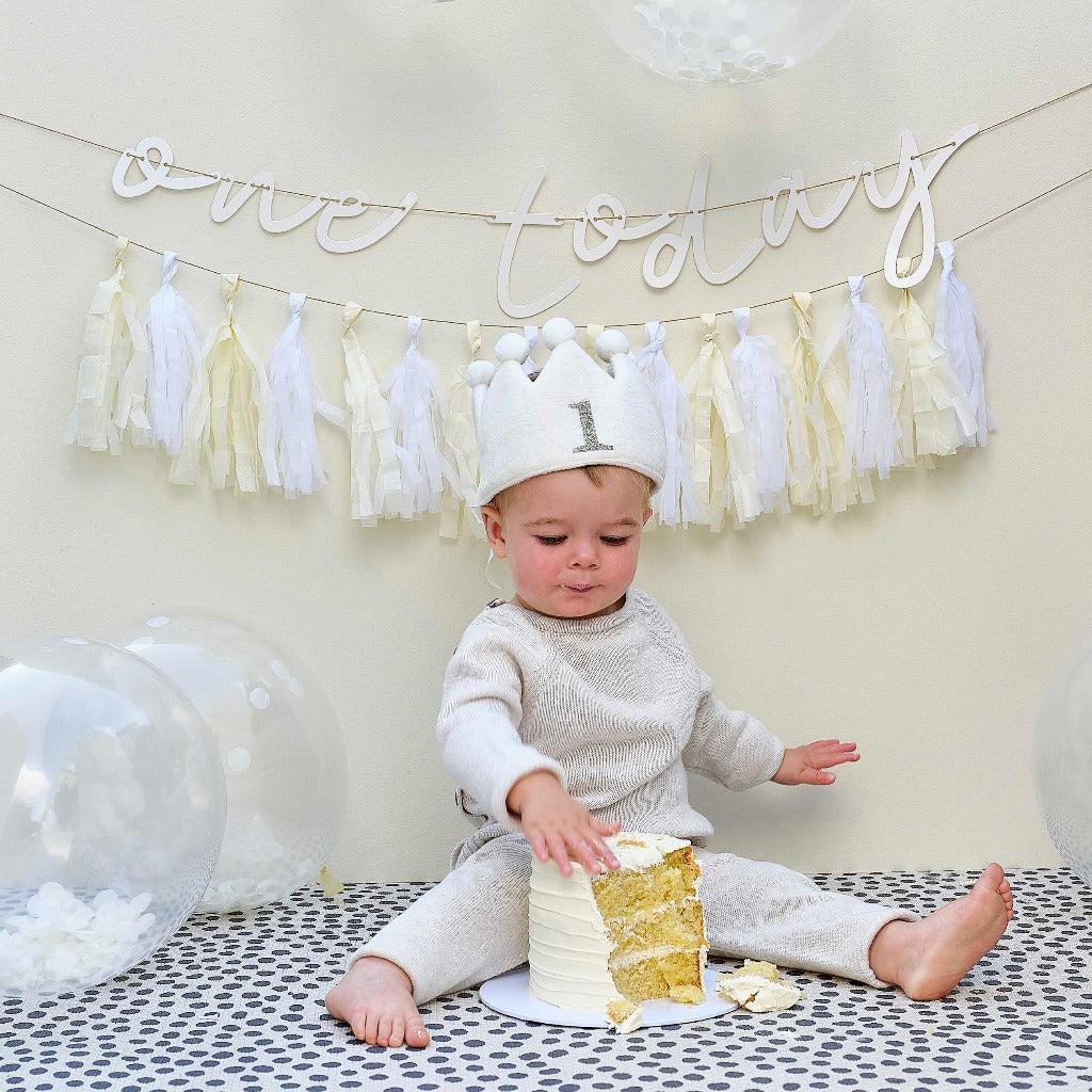 white fabric first birthday crown with white pom poms