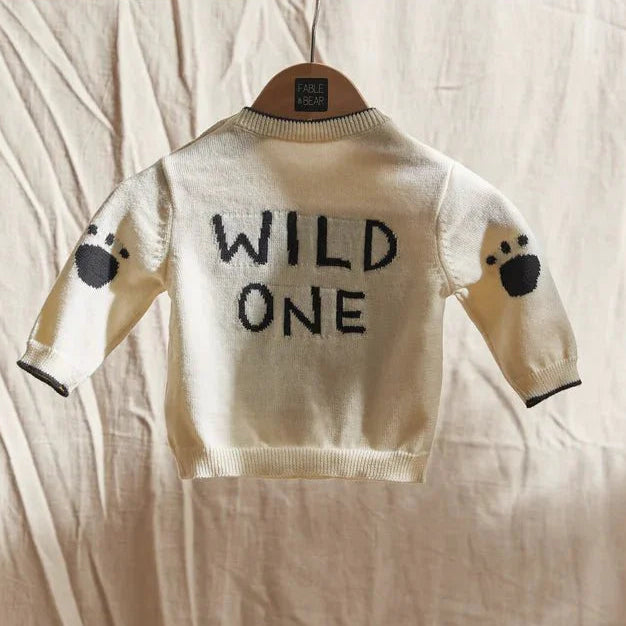 organic baby jumper in cream with blkack lion face and writing on the back wild one
