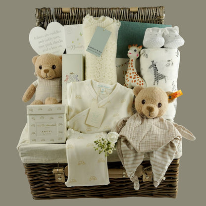 Luxury baby gifts in a hamper basket, Luxury New Mum candle , Angel Wings 2 piece baby clothing set in cream with gold angel wing design, baby hairbrush, baby cashmere shawl, sophie la giraffe, organic steiff teddy and comforter, baby jourmal , baby slippers and baby swaddle in white with grey safari animals
