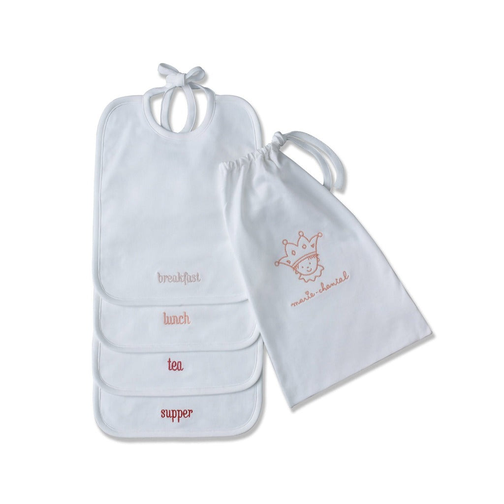white luxury bibs with breakfast, lunch, tea and supper embroidered in terracotta colours  in a gift box with a white drawstring bag with Marie Chantal emblem