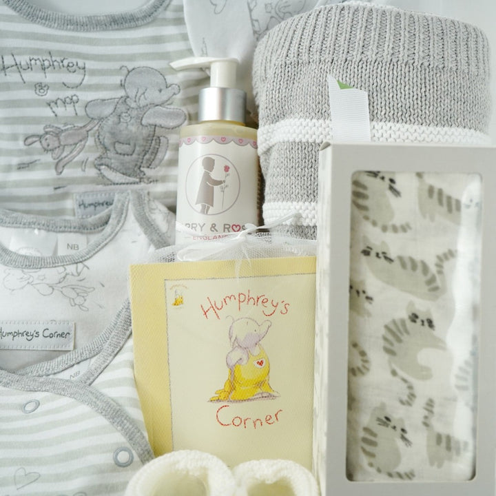 neutral baby hamper in a white gift box, includes an grey and white Humphreys corner baby clothing set and booklet, grey and white cotton blanket, grey and white bamboo and cotton swaddle and white knit baby booties