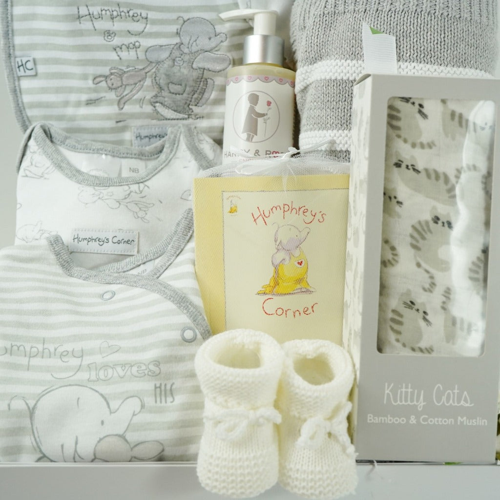 neutral baby hamper in a white gift box, includes an grey and white Humphreys corner baby clothing set and booklet, grey and white cotton blanket, grey and white bamboo and cotton swaddle and white knit baby booties