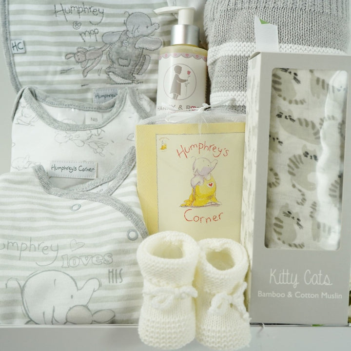 neutral baby hamper in a white gift box, includes an grey and white Humphreys corner baby clothing set and booklet, grey and white cotton blanket, grey and white bamboo and cotton swaddle and white knit baby booties