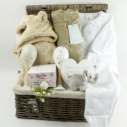 neutral baby gift in wicker hamper basket, baby dressing gown with ears, white designer baby outfit, baby maracs, mummy toiletries, steiff elephant rattle, G H Hurt baby shawl