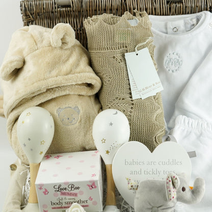 neutral baby gift in wicker hamper basket, baby dressing gown with ears, white designer baby outfit, baby maracs, mummy toiletries, steiff elephant rattle, G H Hurt baby shawl