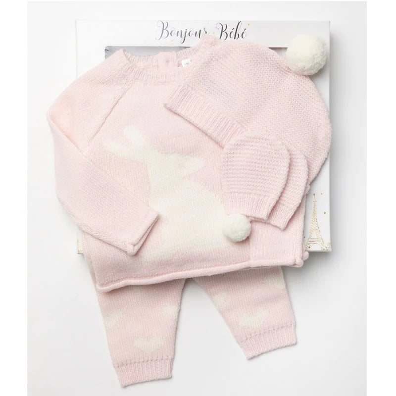Knitted baby set in pink and white in a gift box, kitted jumper in pink with a rabbit in white with a pom pom tail, pink knitted gloves , pink kitted hat with a white pom pom , pink knitted leggings with white heart