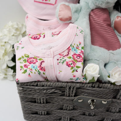 Grey hamper basket, baby girl pink floral baby clothing set, Little but fierce elephant lovey, pink baby booties, pink and white luxury baby blanket, organic baby toiletries by Little Butterfly Londo