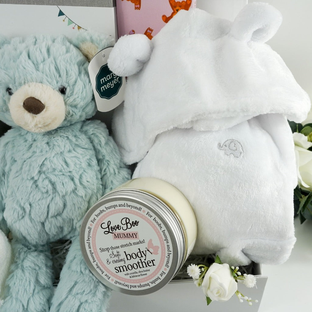 antenatal pregnancy hamper with baby scan photo frame , pale blue/green soft baby teddy, pregnancy and first year of life journal in a grey cover, cute white baby dressing gown with cute ears, white knit baby booties, fairy tale inspired chocolate