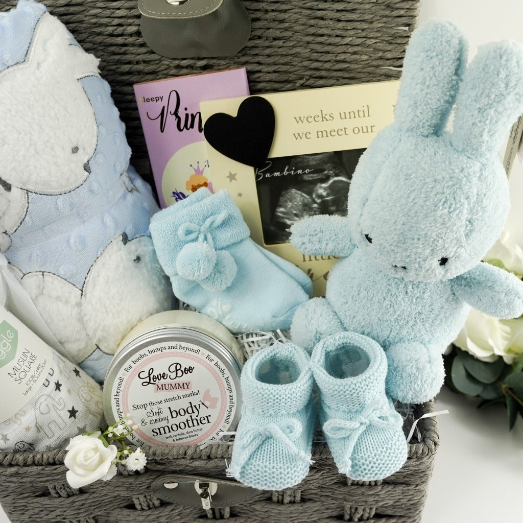 Grey hamper basket, white and grey baby muslin with elephants, Love boo mummy body butter , boutique luxury chocolate bar, pale blue miffy bunny rabbit, blue knit baby booties, pregnancy countdown frame with chalk board heart, pale blue soft sherpa backed baby blanket with applique bunny and teddy