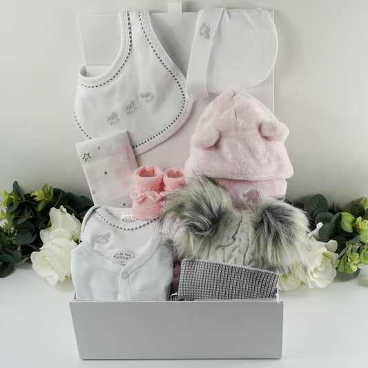 White magnetic hamper box with ribbon tab, include is a white baby layette with silver embroidered rocking horses which includes a baby sleep suit , baby vest., baby mittens, baby hat and baby bib. Pink soft fleece dressing gown with cute ears, pink knit bootis with toies, soft grey and cream fluffy double pom pom hat 