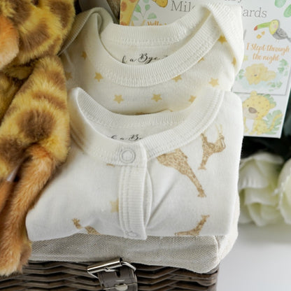 Luxury wicker hamper basket filled with baby gifts including baby clothing set in cream with a giraffe , includes baby sleepsuit, baby vest, baby bib, baby mittens, baby hat, Sophie La Giraffe So Pure rubber teething toy boxed, soft cream baby blanket with giraffe, giraffe soft toy, giraffe comforter, giraffe rattle ring toy, luxury gingerbread toffe chocolate in luxury wrapper, baby knit booties in white with tie, memorable moments baby cards with pastel animals