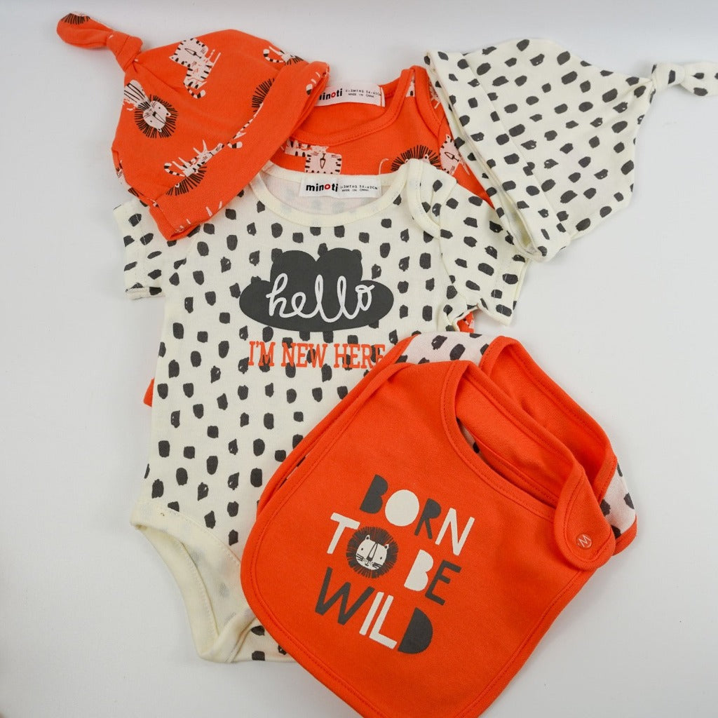 Baby suitcase with 2 bodysuits one orange one cream and grey with matching knot baby hats and bibs, white knit booties, wooden star shaped baby teether, white cotton cellular blanket, white bear rattle