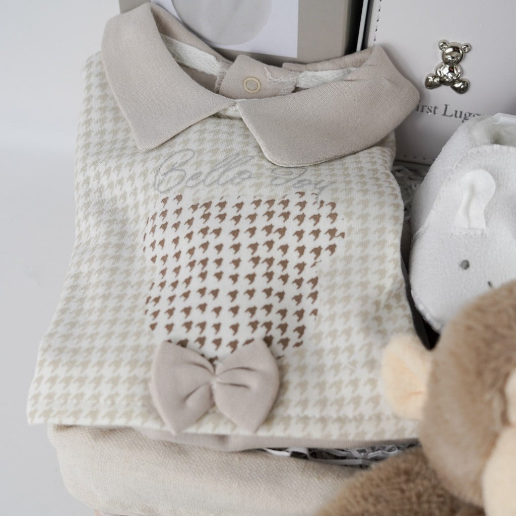Neutral Baby hamper with monkey soft toy, monkey baby comforter, baby booties, baby's first passport holder and luggage label in white with a silver teddy, clay footprint hanger, baby star wooden teether, spanish style baby sleepsuit