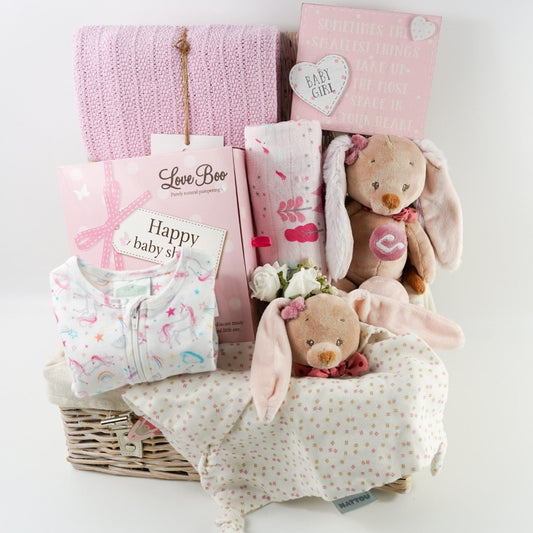 Pink  themed baby shower gift hamper , baby zip up sleepsuit with unicorns in pink and white , natural baby toiletries , patel taupe rabbit with pink eats musical and matching rabbit baby comforter , unicorn pink muslin , pink heavy weight baby cellular blanket , nursery plaque 
