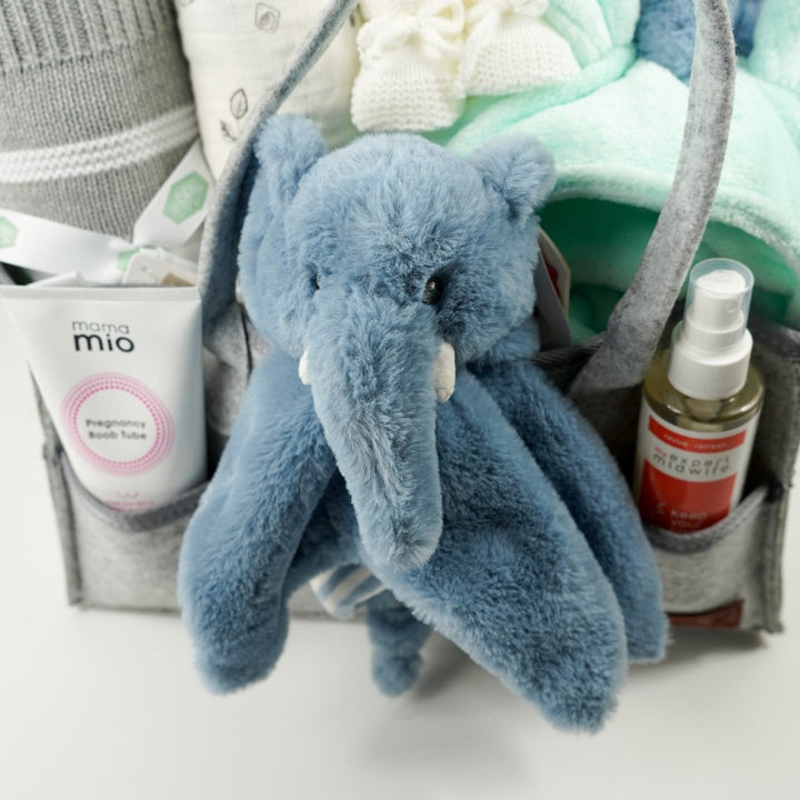 nappy caddy with baby gifts including a mint green baby dressing gown, mint green lion face hooded baby towel, baby blanket grey and white, muslin, soft cuddly ecofriendly elephant in blue and matching comforter, pregnancy toiletries