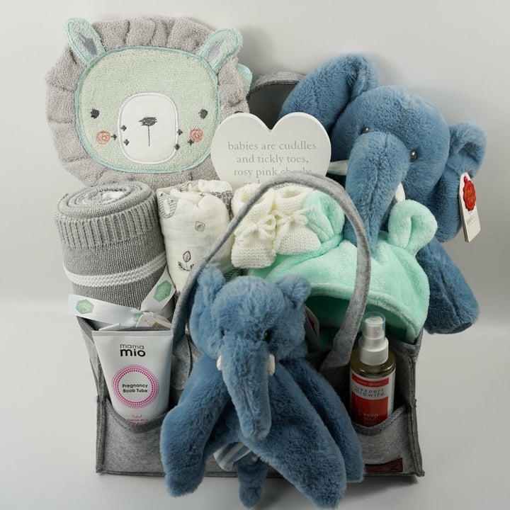 nappy caddy with baby gifts including a mint green baby dressing gown, mint green lion face hooded baby towel, baby blanket grey and white, muslin, soft cuddly ecofriendly elephant in blue and matching comforter, pregnancy toiletries 