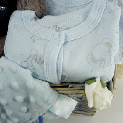 baby sleepsuit set in pale blue with silver elephants. Baby ribbon tabbed taggie comfort blanket is pale blue 