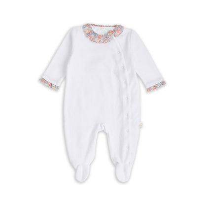 White velour baby sleepsuit with liberty print ruffle collar and libertiy print wings and trims around the cuffs, the sleepsuit is a soft velour