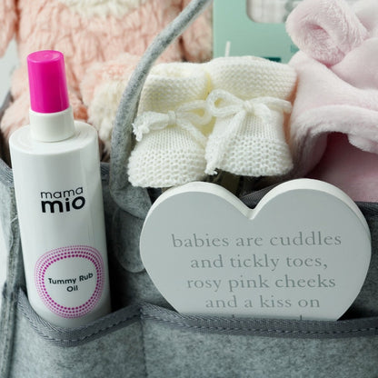 grey nappy caddy full of pregnancy gifts including mum to be tummy rub oil, musical pink rabbit, baby pink dressing gown, baby white sleeping bag with grey koalas. pregnancy countdown plaque, baby bootees