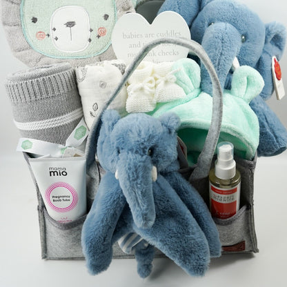 nappy caddy with baby gifts including a mint green baby dressing gown, mint green lion face hooded baby towel, baby blanket grey and white, muslin, soft cuddly ecofriendly elephant in blue and matching comforter, pregnancy toiletries