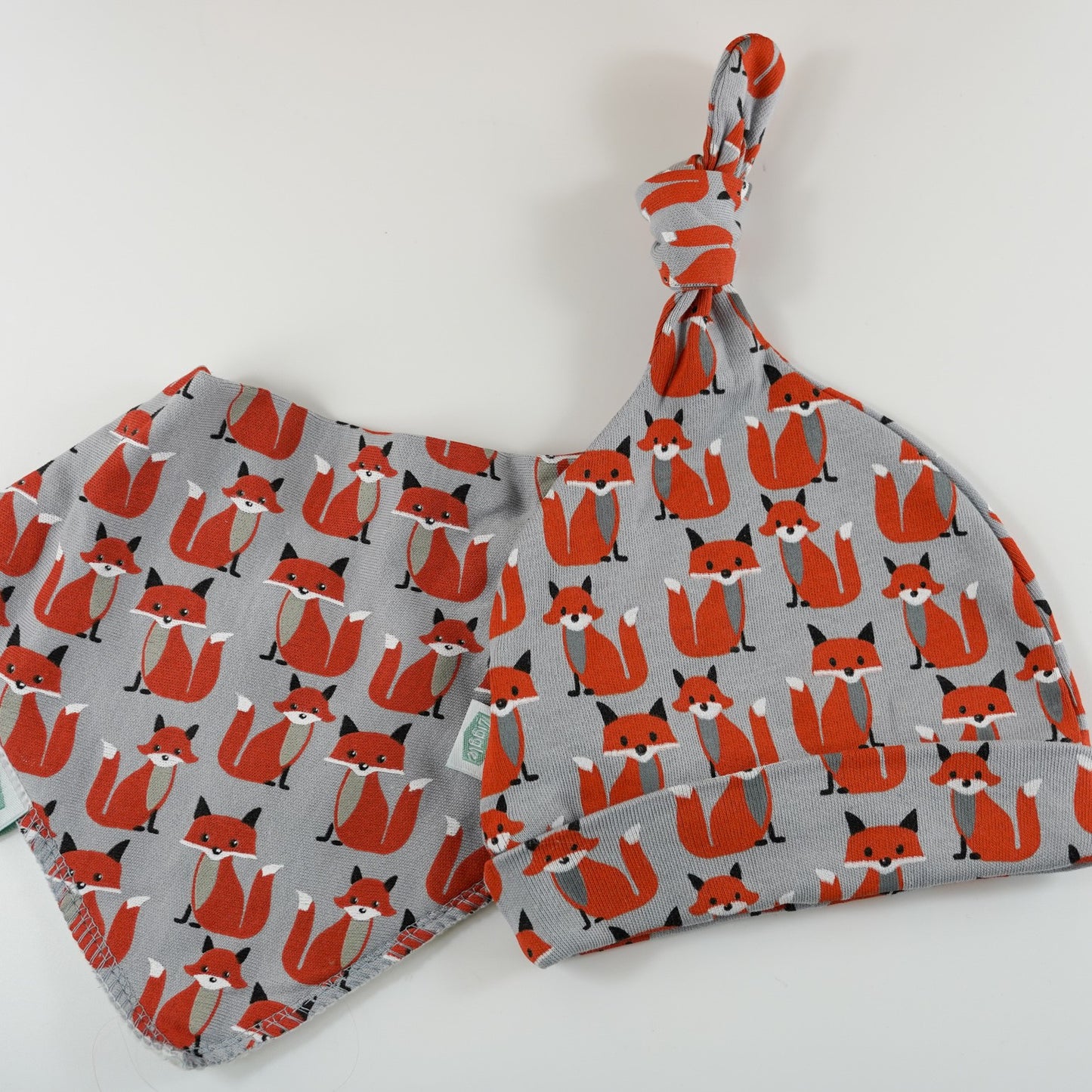 baby grey knot hat with orange foxes and matching bandana bib by Ziggle 